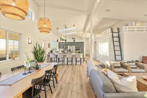 Living area with high vaulted ceiling, light wood finished floors, and recessed lighting