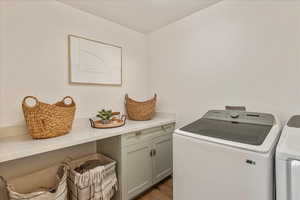 Washroom featuring washing machine and dryer and light wood finished floors