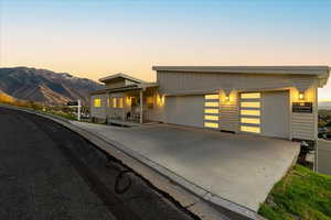 View of front of property with driveway, a garage, and covered porch