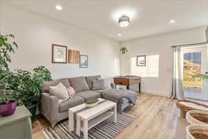 Living area with light wood-style flooring and recessed lighting