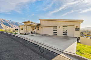 View of front of house with a mountain view, driveway, an attached garage, and board and batten siding