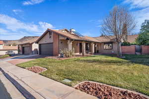 Single story home featuring solar panels, stucco siding, driveway, a porch, and a garage