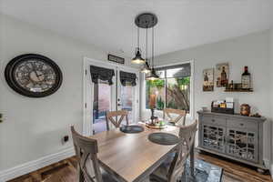 Dining area with french doors and dark wood-type flooring