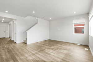 **DISCLAIMER** Interior color package may vary.Unfurnished living room with stairs, recessed lighting, and light wood finished floors