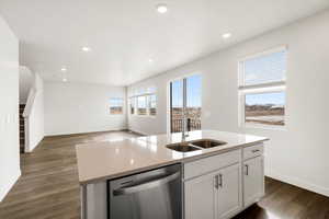 **DISCLAIMER** Interior color package may vary.Kitchen with dishwasher, white cabinetry, an island with sink, dark wood-type flooring, and light stone countertops