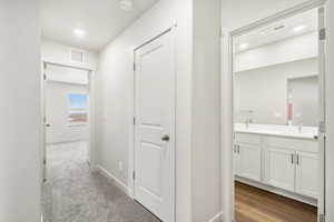 Corridor featuring recessed lighting and dark carpet