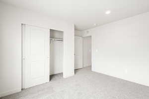 **DISCLAIMER** Interior color package may vary.Unfurnished bedroom featuring light carpet and a closet
