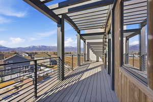 Wooden deck featuring a mountain view, a residential view, and a pergola
