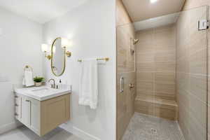 Full bathroom with a stall shower, vanity, and light tile patterned floors