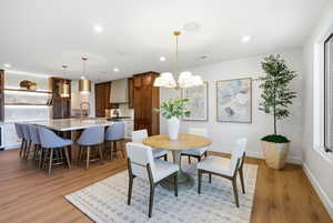 Dining area with light wood-style floors, recessed lighting, and a chandelier