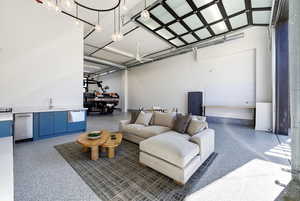 Living area featuring a towering ceiling and dark speckled floor