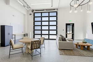 Dining room featuring a towering ceiling and dark speckled floor