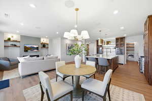 Dining room with light wood finished floors and recessed lighting