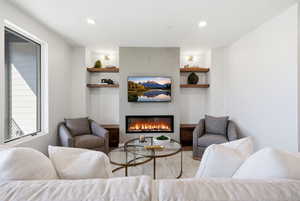 Living room featuring a glass covered fireplace and recessed lighting