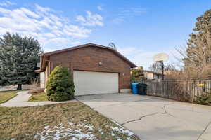 View of home's exterior with brick siding and driveway