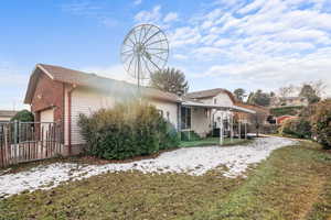 Rear view of property featuring a patio, an attached garage, a gate, and brick siding