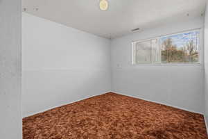 Spare room featuring a textured ceiling and carpet
