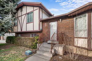 View of front of house featuring brick siding and stucco siding