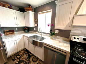 Stainless farm sink. White cottage cabinets.