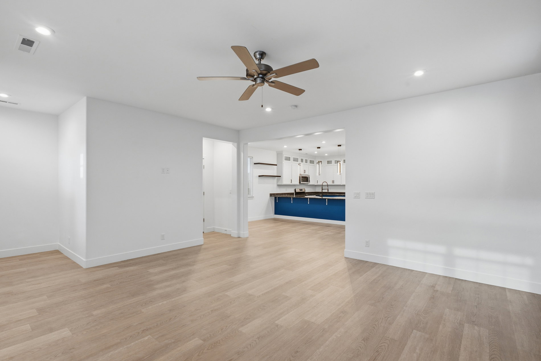 Unfurnished living room with light wood-type flooring, recessed lighting, and a ceiling fan