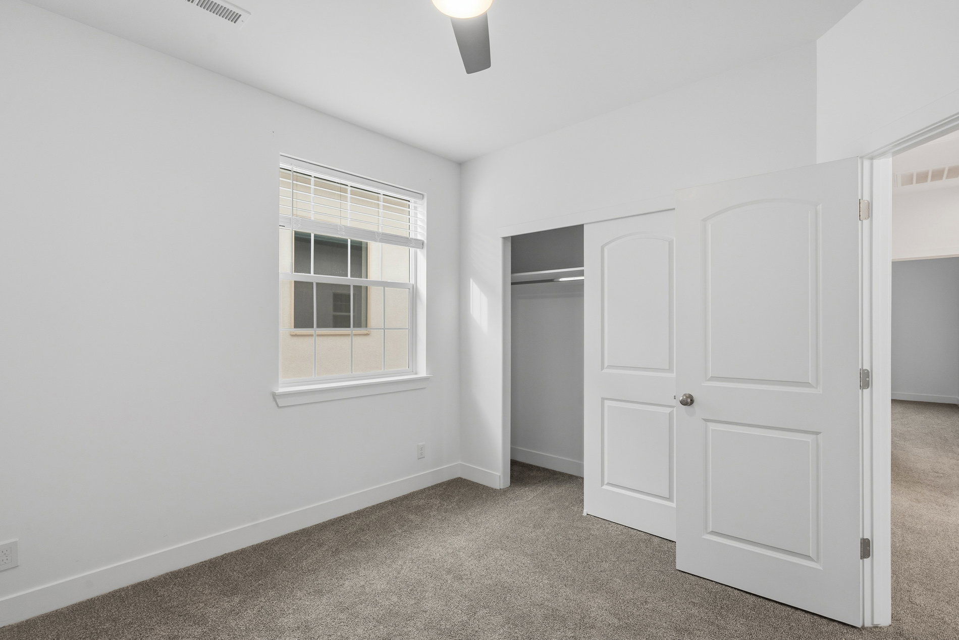 Unfurnished bedroom with carpet floors, a closet, and a ceiling fan