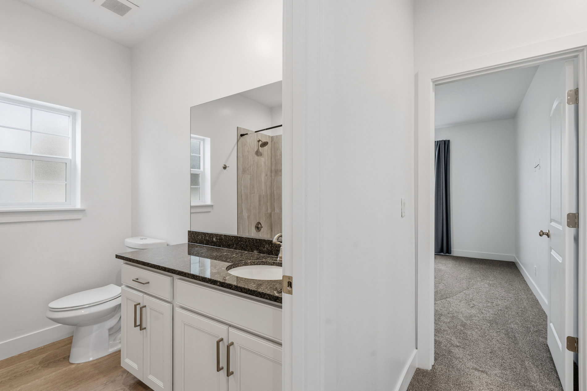 Bathroom featuring a tile shower and vanity