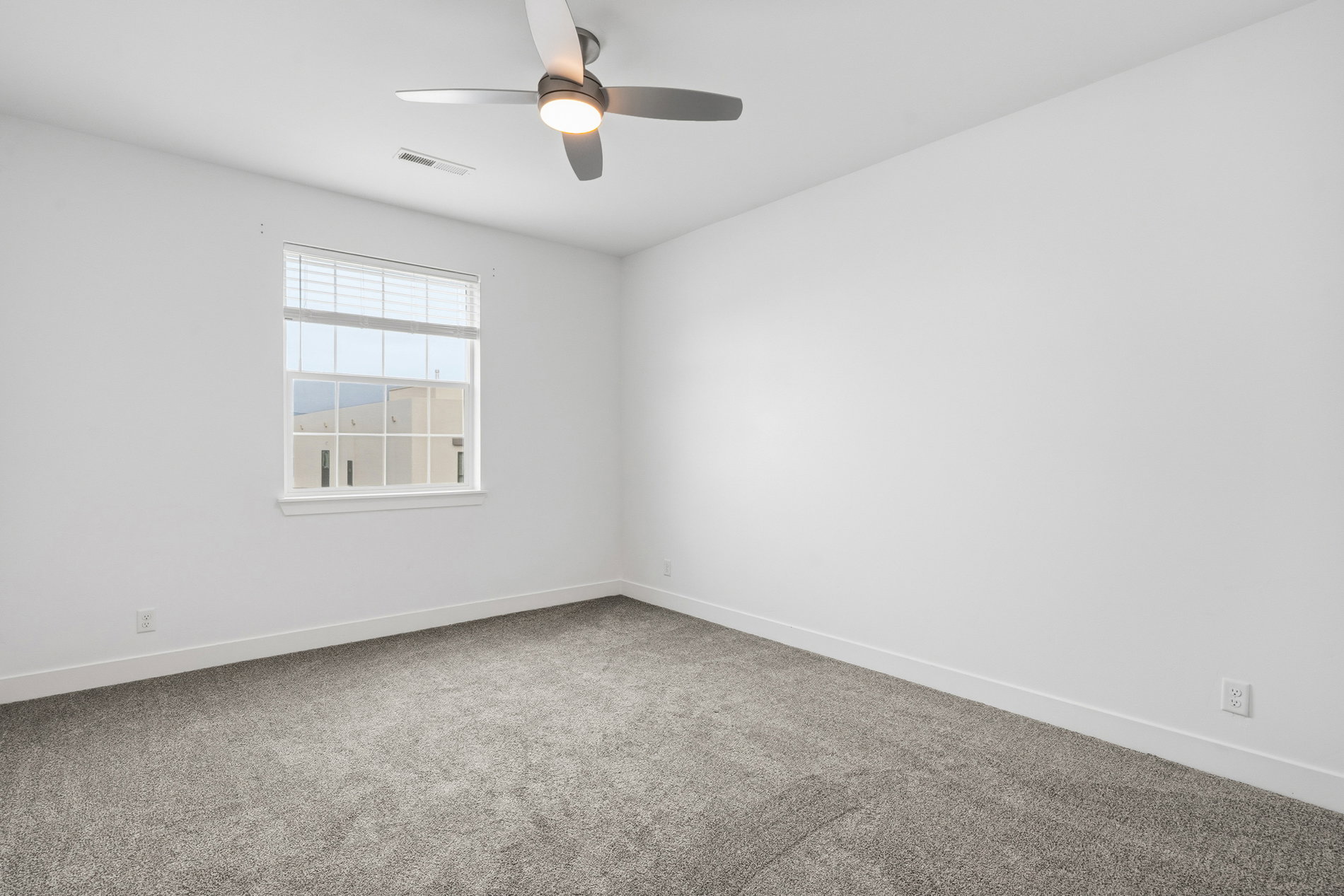 Spare room featuring light colored carpet and ceiling fan