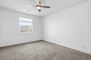 Spare room featuring light colored carpet and ceiling fan