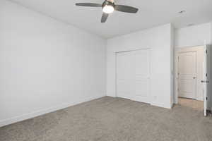 Unfurnished bedroom with carpet flooring, a closet, and a ceiling fan