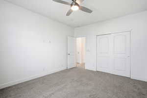 Unfurnished bedroom with carpet, a closet, and ceiling fan