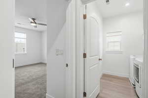 Washroom featuring washing machine and dryer, ceiling fan, light wood-style flooring, and recessed lighting