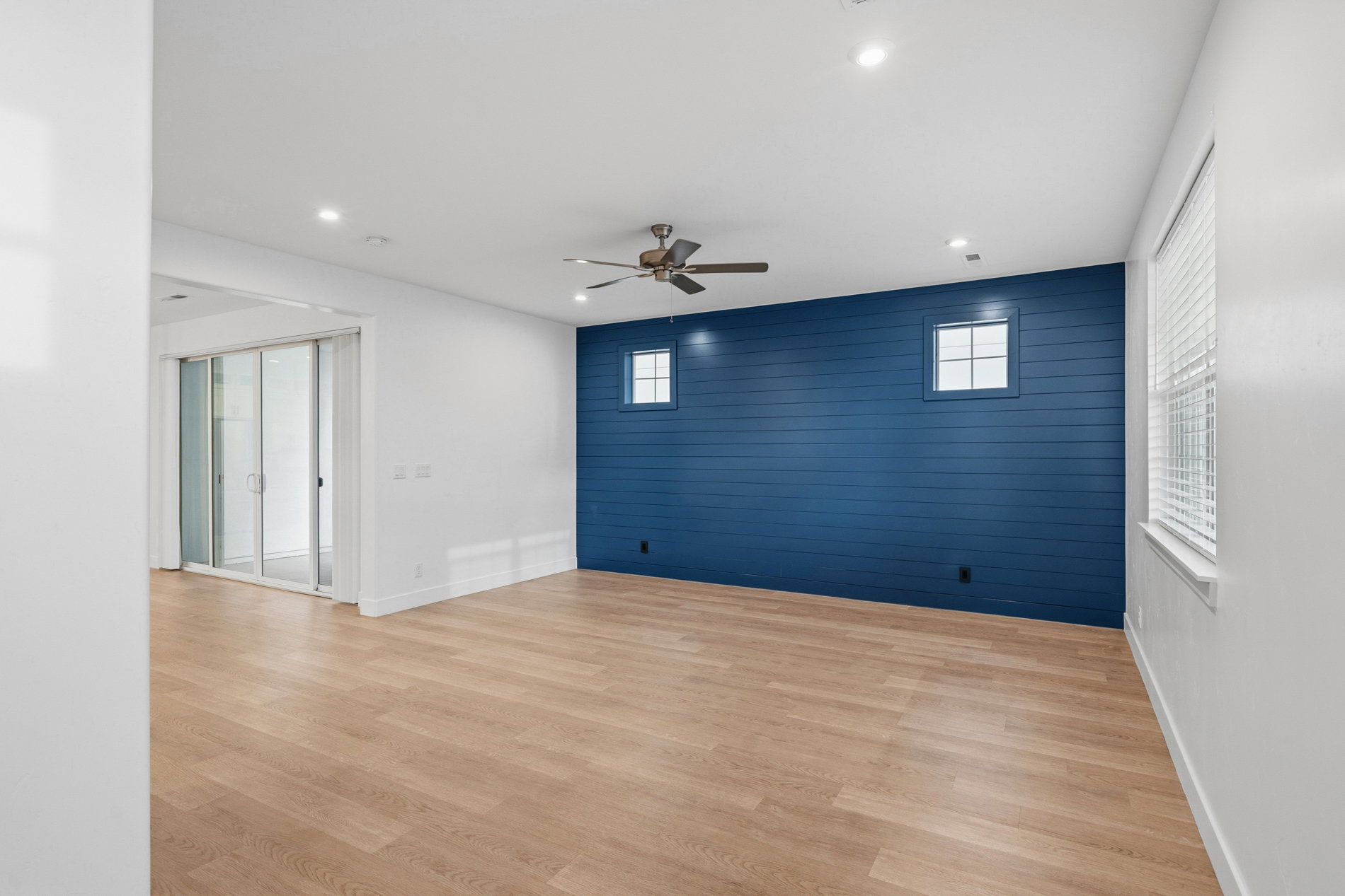 Empty room featuring wood walls, an accent wall, light wood finished floors, ceiling fan, and recessed lighting
