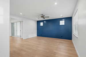 Empty room featuring wood walls, an accent wall, light wood finished floors, ceiling fan, and recessed lighting