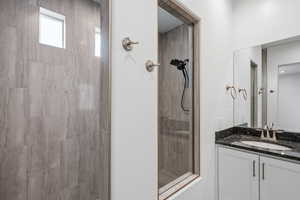 Full bathroom featuring tiled shower and vanity