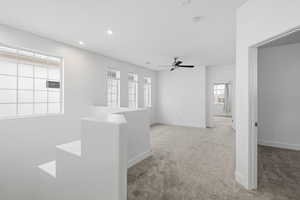 Empty room featuring light colored carpet, ceiling fan, and recessed lighting