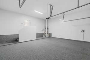 Garage with baseboards and secured water heater
