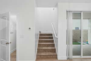 Stairs with baseboards and wood finished floors