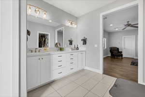 Full bath featuring double vanity, light tile patterned floors, a walk in closet, ceiling fan, and recessed lighting