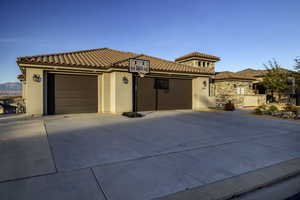 Mediterranean / spanish-style house featuring stucco siding, a garage, and driveway