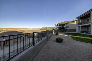 View of green lawn featuring a balcony, a patio, and a trampoline