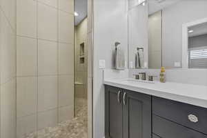 Bathroom with vanity, walk in shower, and recessed lighting