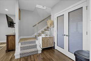 Stairway featuring french doors and wood finished floors