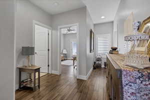 Hall with baseboards and dark wood-style floors