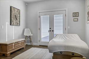 Bedroom featuring access to exterior, wood finished floors, and french doors