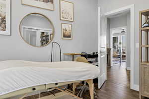 Bedroom featuring wood finished floors and an office area