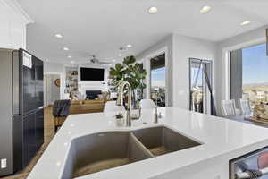 Kitchen featuring freestanding refrigerator, a fireplace, recessed lighting, open floor plan, and light wood-style flooring