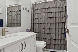 Full bathroom featuring curtained shower and vanity