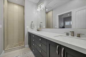 Bathroom featuring double vanity, light tile patterned flooring, recessed lighting, and a walk in shower