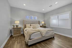 Bedroom featuring wood finished floors, multiple windows, and recessed lighting