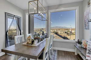 Dining area featuring wood finished floors, a residential view, a chandelier, and a mountain view